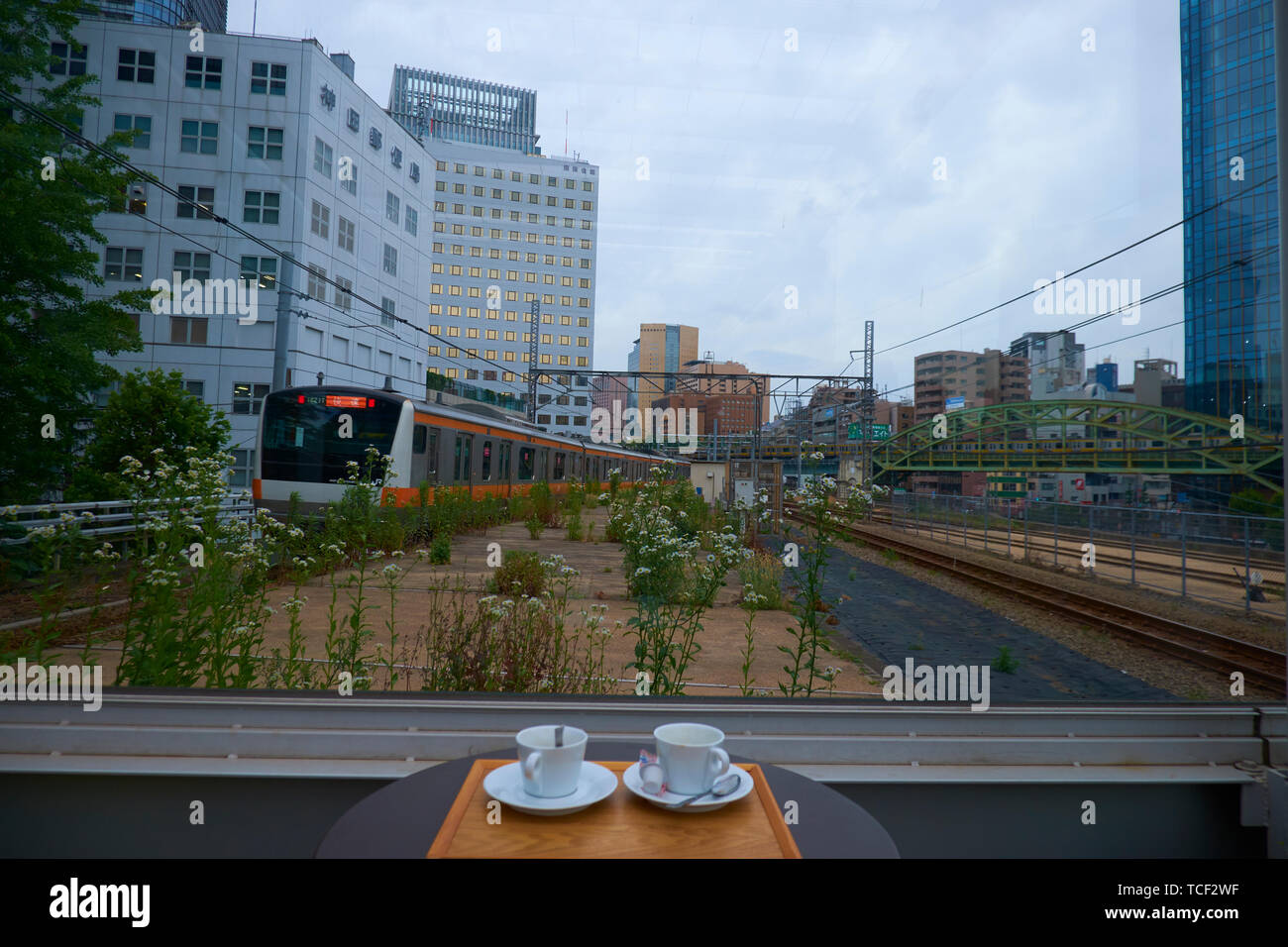 A train going right by a rooftop cafe at the Maach shopping arcade in