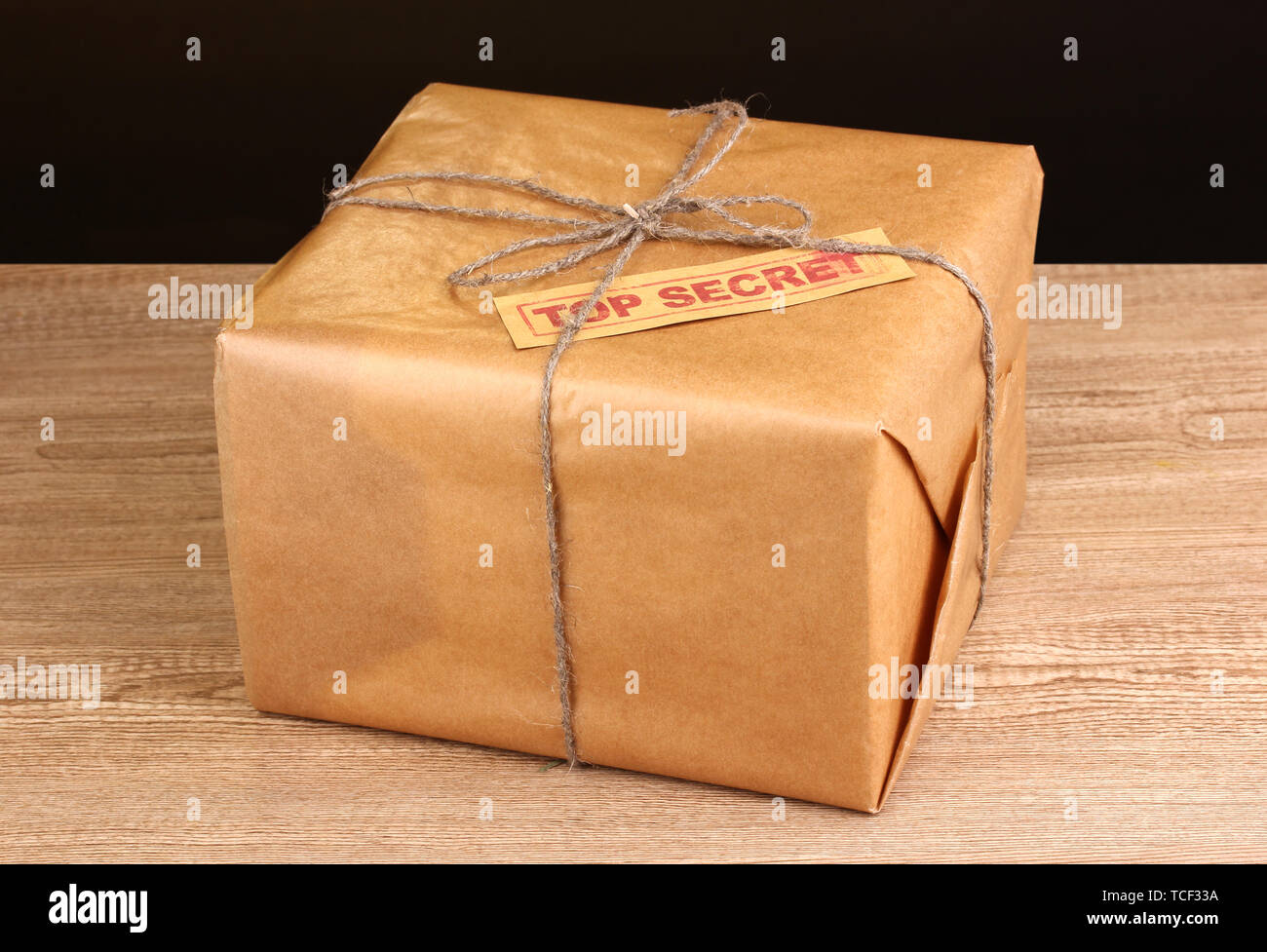 Parcel with top secret stamp on wooden table on brown background Stock Photo