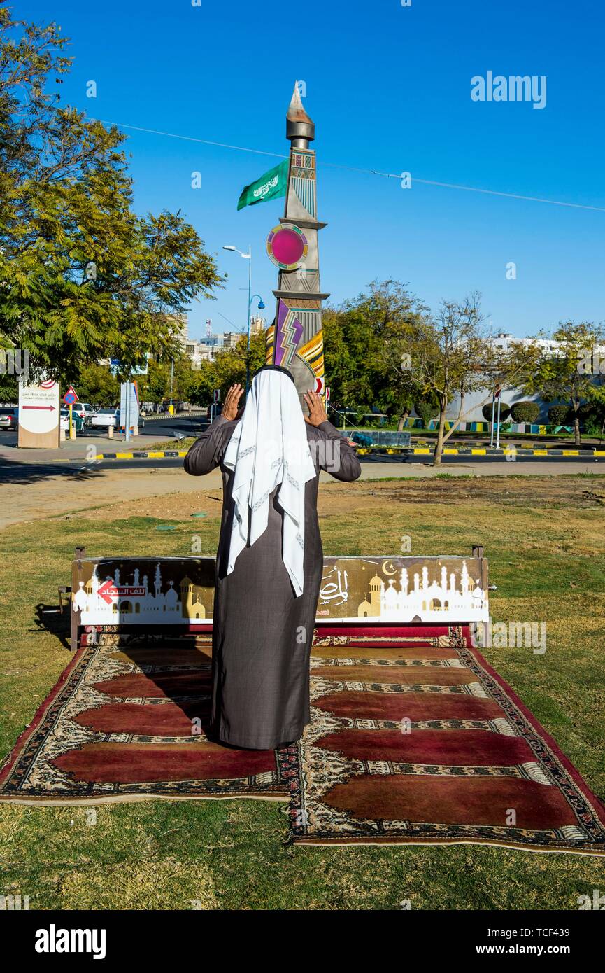 Man praying on a mobile praying rug, Abha, Saudi Arabia Stock Photo