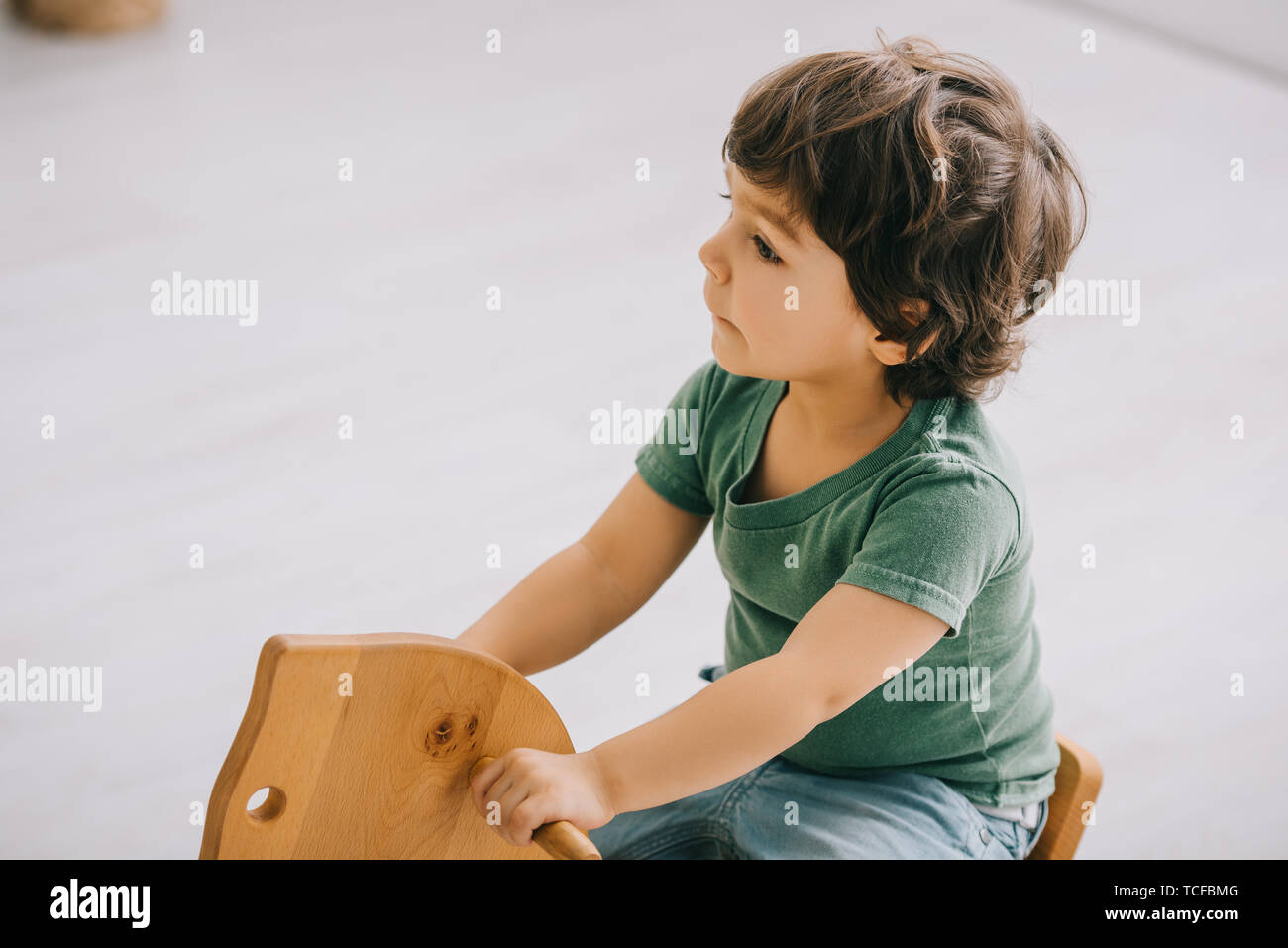 kid sitting on wooden rocking horse in living room Stock Photo Alamy