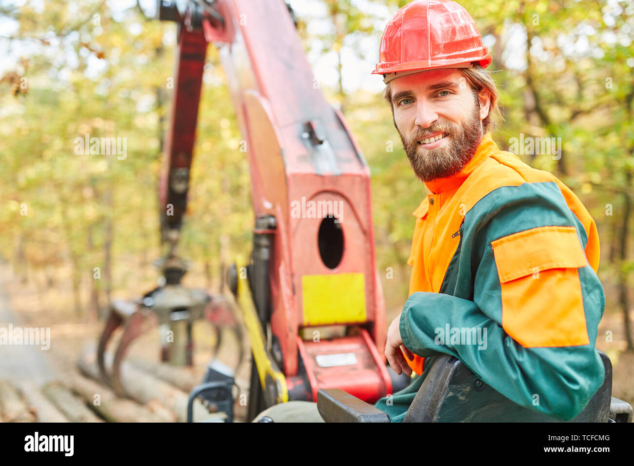 Smiling crane operator in logging on the forest crane of Forwarder in