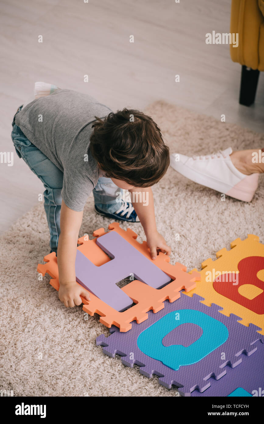 child playing with alphabet puzzle mat on carpet Stock Photo Alamy