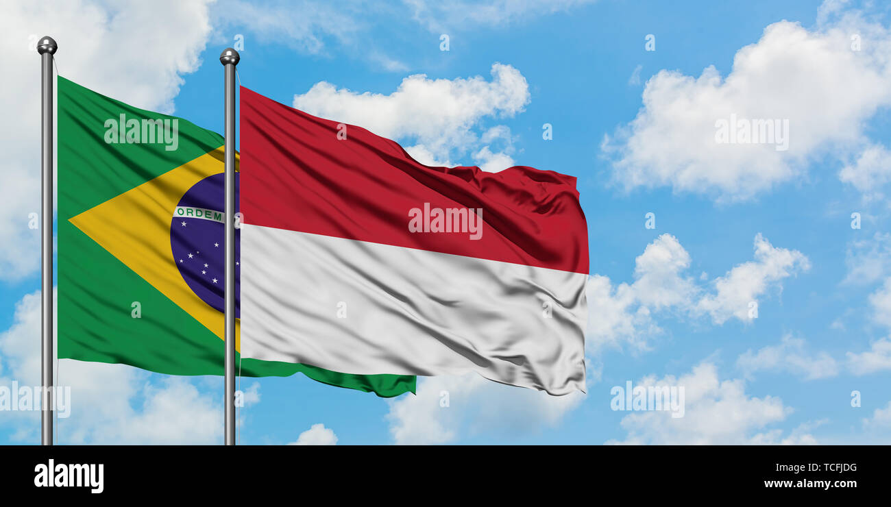 Brazil and Indonesia flag waving in the wind against white cloudy blue ...