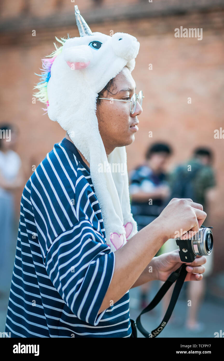 An Asian tourist enjoys the sights taking photos by the famous Tha Pae Gate, Chiang Mai, Thailand. Stock Photo