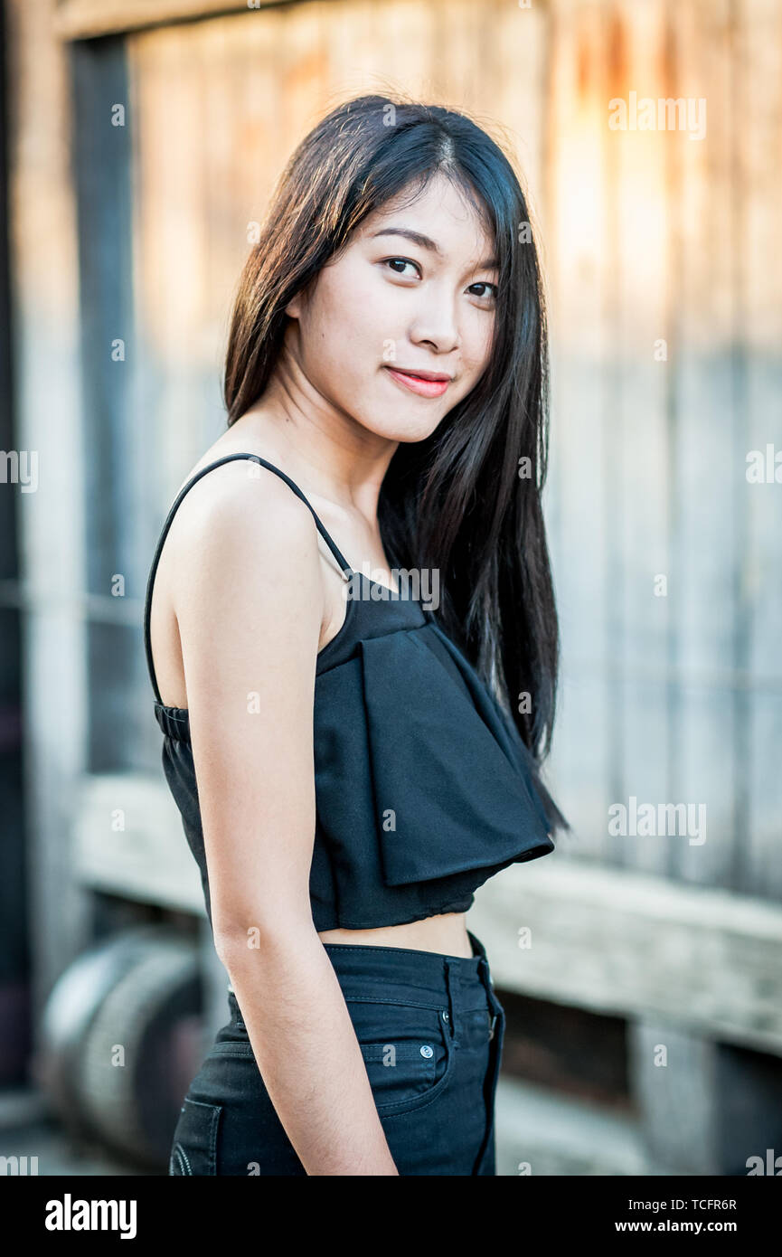 A beautiful Thai girl poses at the famous tourist landmark Pae Gate, Chiang Mai, Thailand. Stock Photo