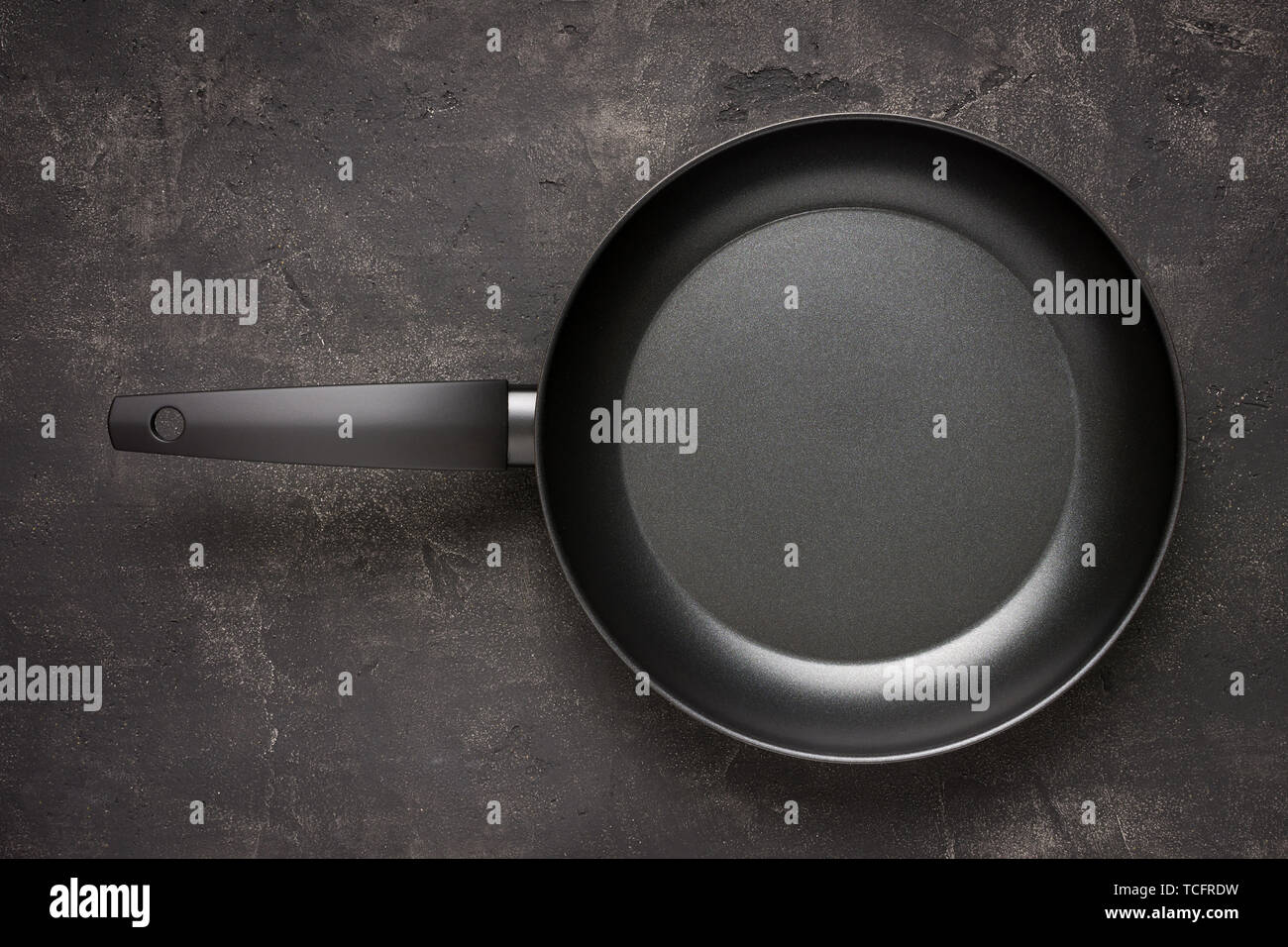 Empty Frying Pan Black on Dark Stone Surface. Culinary Background. Stock Photo