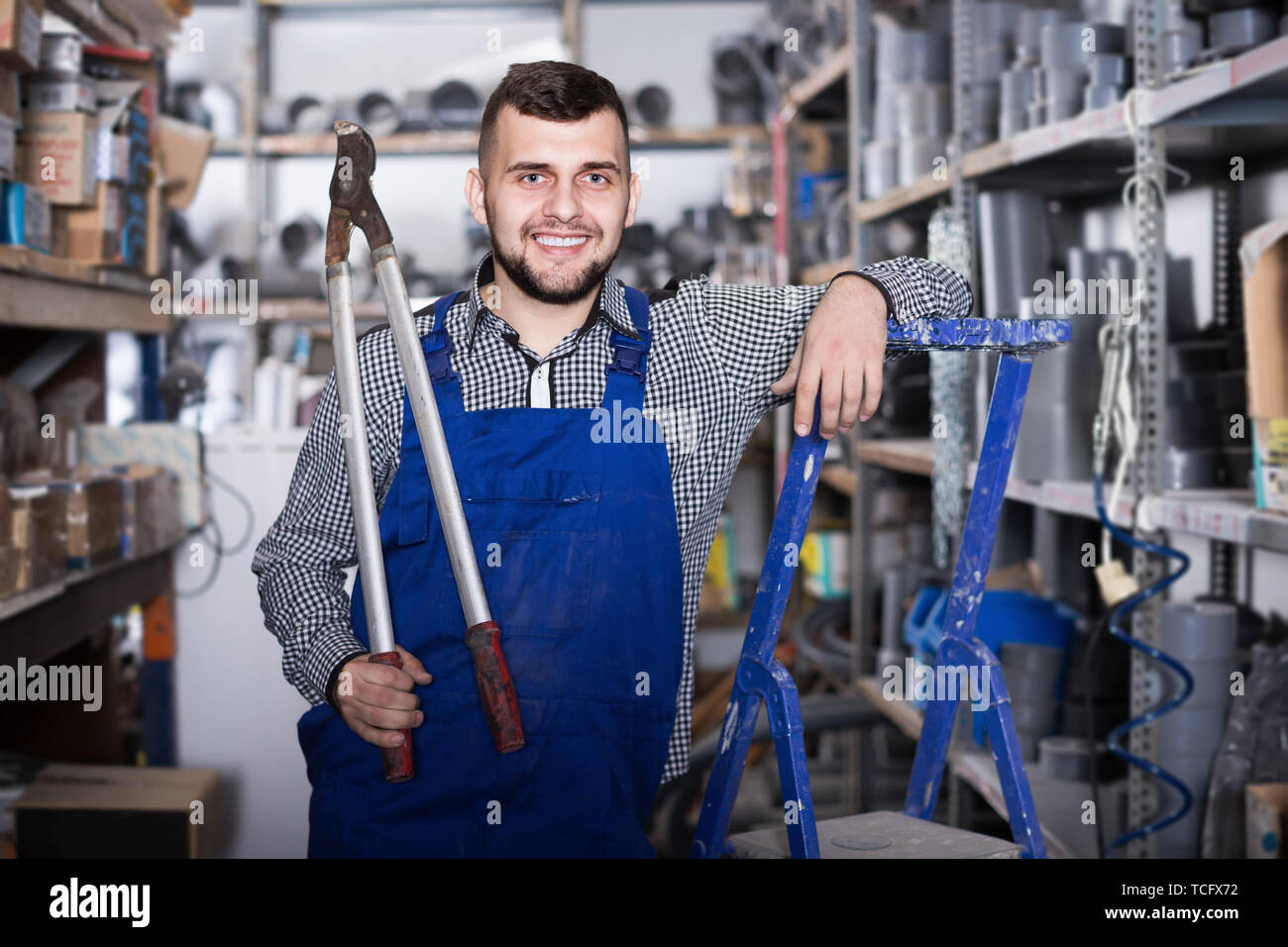 Smiling man worker showing various instruments at workplace Stock Photo ...