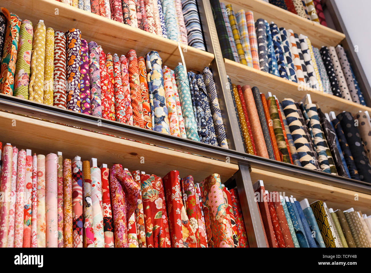 View of cloth rolls of different colors and patterns on shelves in ...