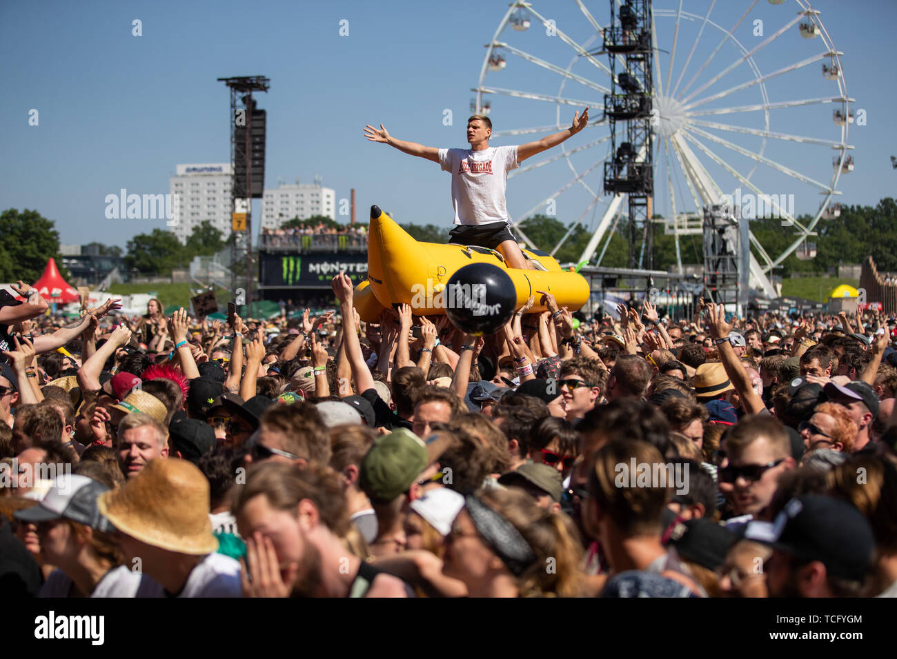 Nuremberg, Germany. 07th June, 2019. A visitor of the open-air festival 'Rock im Park' is carried over the crowd by other visitors during a concert on an inflatable banana. The music festival runs until 9 June 2019. Credit: Daniel Karmann/dpa/Alamy Live News Stock Photo