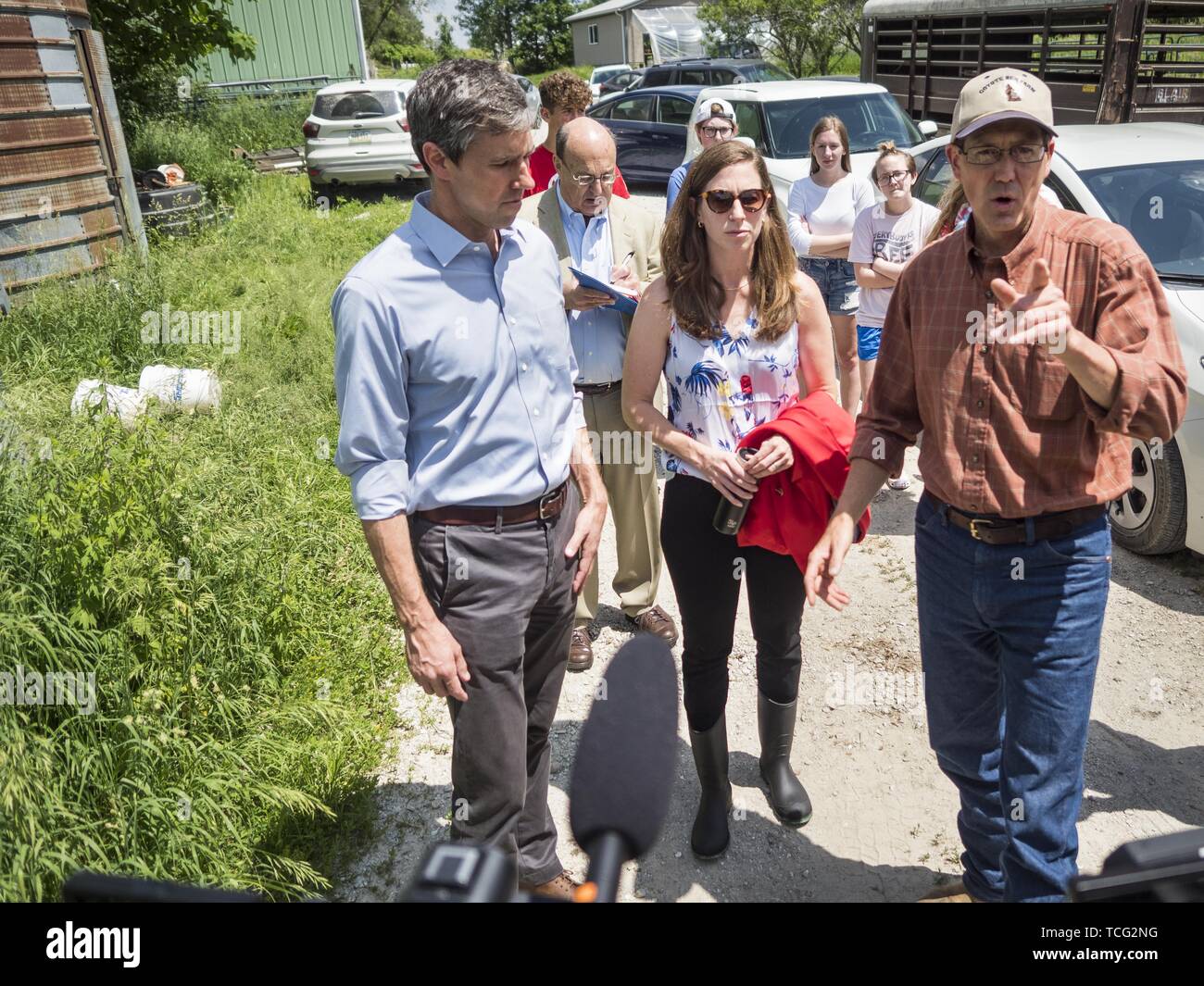 Iowa, USA. 07th June, 2019. Lacona, Iowa, USA. 7th June, 2019. BETO O'ROURKE, left, his wife, AMY O'ROURKE, and MATT RUSSELL talk while they tour Russell's farm, Coyote Run Farm. O'Rouke toured Coyote Run Farm in Lacona Friday. He talked to Russell, the farm's co-owner, about the impact of President Trump's tariffs against China and proposed tariff's against Mexico on Iowa farmers and how climate change was changing American agriculture. O'Rourke, running to be the 2020 Democratic nominee for the US Presidency, has made climate change a central part of his campaign. Credit: ZUMA Press, Inc./Al Stock Photo