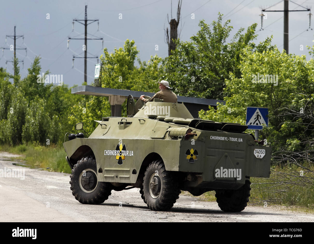 Kiev, Ukraine. 7th June, 2019. SERGII MIRNI, a radiation reconnaissance officer who participated in the compilation of the first maps of radiation pollution in 1986, rides on an armored personnel carrier at the Dityatki checkpoint in Chernobyl, Ukraine, on 7 June 2019. The success of a U.S. HBO's television miniseries 'Chernobyl' has renewed interest around the world on Ukraine's 1986 nuclear disaster. Tourism to Chernobyl has spiked 40% following the debut of the HBO series in May, tour agencies reported. Credit: ZUMA Press, Inc./Alamy Live News Stock Photo