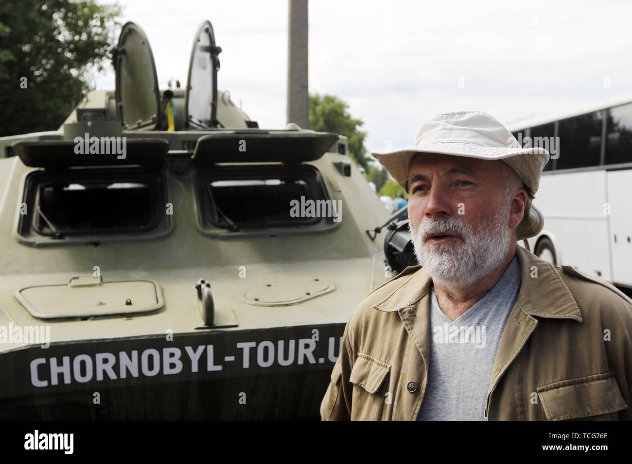 Kiev, Ukraine. 7th June, 2019. SERGII MIRNI, a radiation reconnaissance officer who participated in the compilation of the first maps of radiation pollution in 1986, stands next to an armored personnel carrier at the Dityatki checkpoint in Chernobyl, Ukraine, on 7 June 2019. The success of a U.S. HBO's television miniseries 'Chernobyl' has renewed interest around the world on Ukraine's 1986 nuclear disaster. Tourism to Chernobyl has spiked 40% following the debut of the HBO series in May, tour agencies reported. Credit: ZUMA Press, Inc./Alamy Live News Stock Photo
