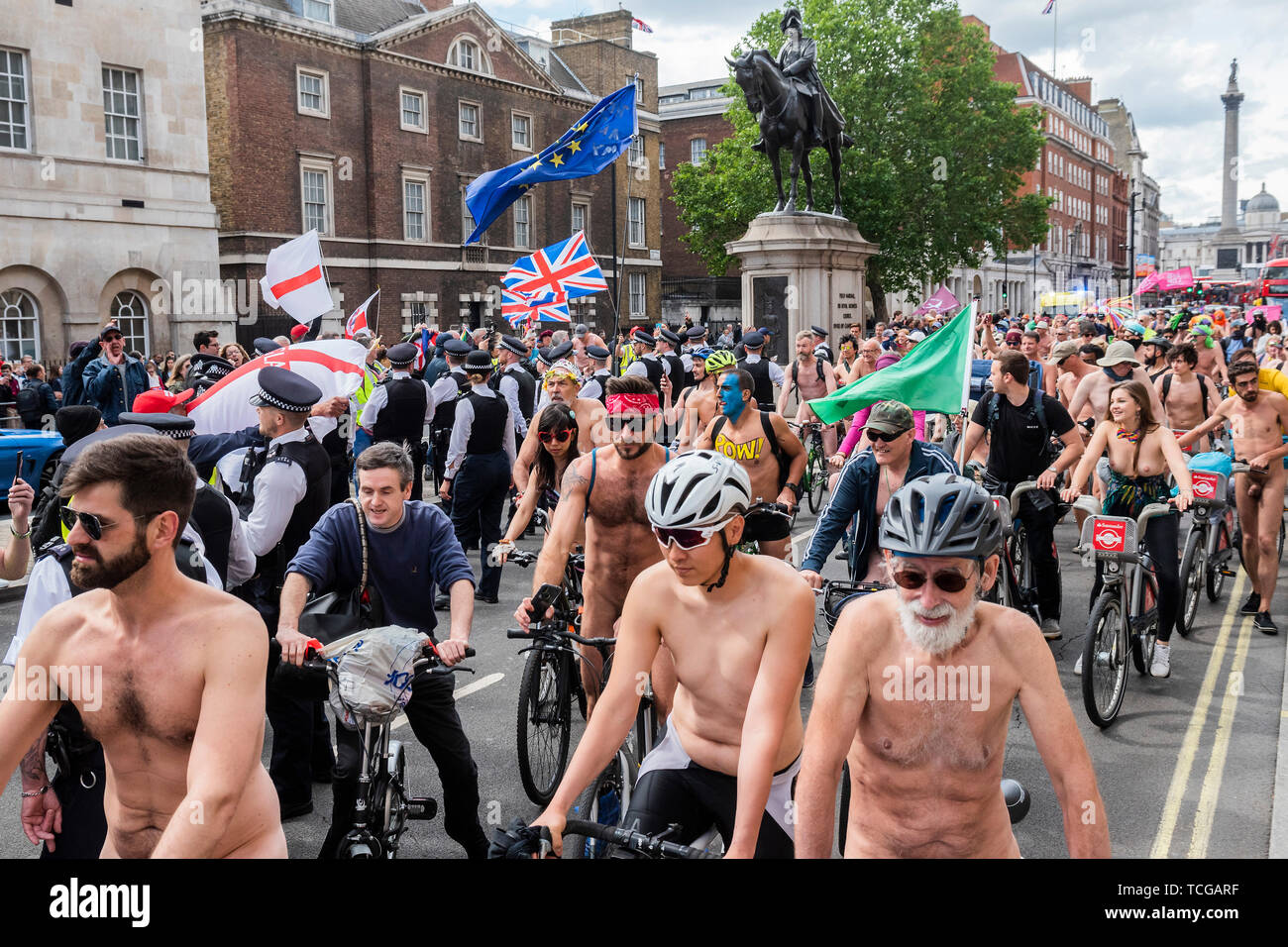 London, UK. 08th June, 2019. Yellow vest pro-brexit protestors in Whitehall  are held back by police as they shout abuse at the cyclists - World Naked  Bike ride, London. Participants ride for