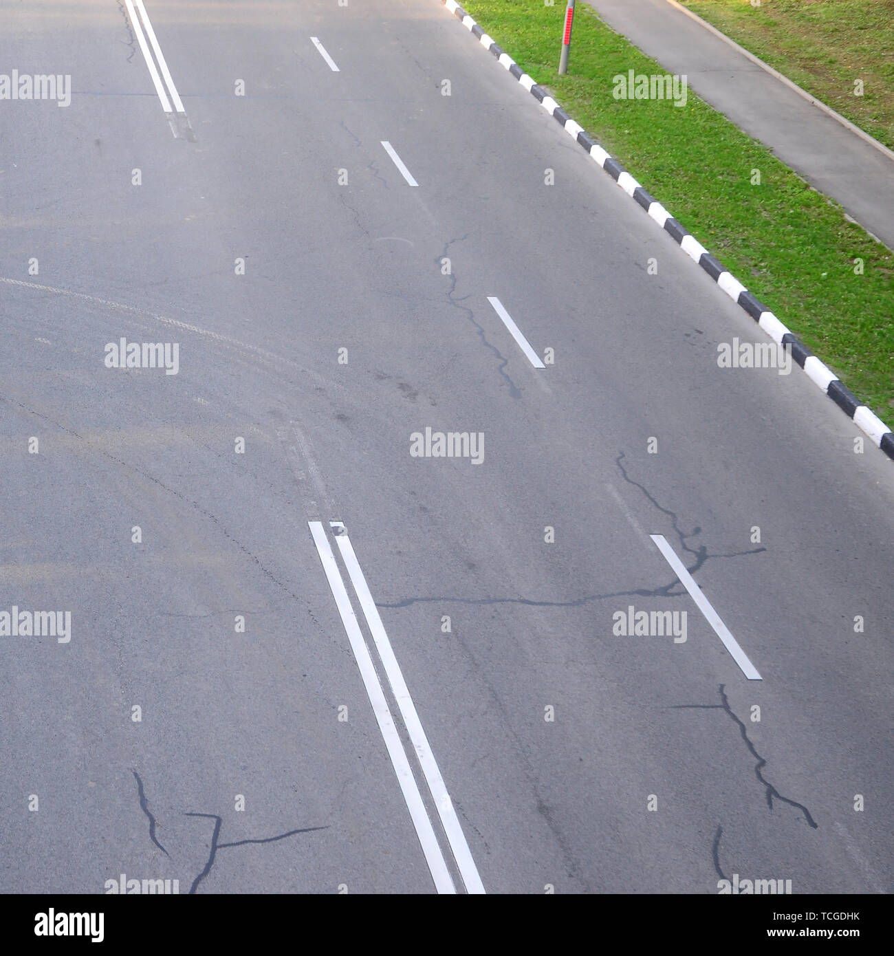 Damaged bad asphalt road with potholes. Patch repair of asphalt. Bad