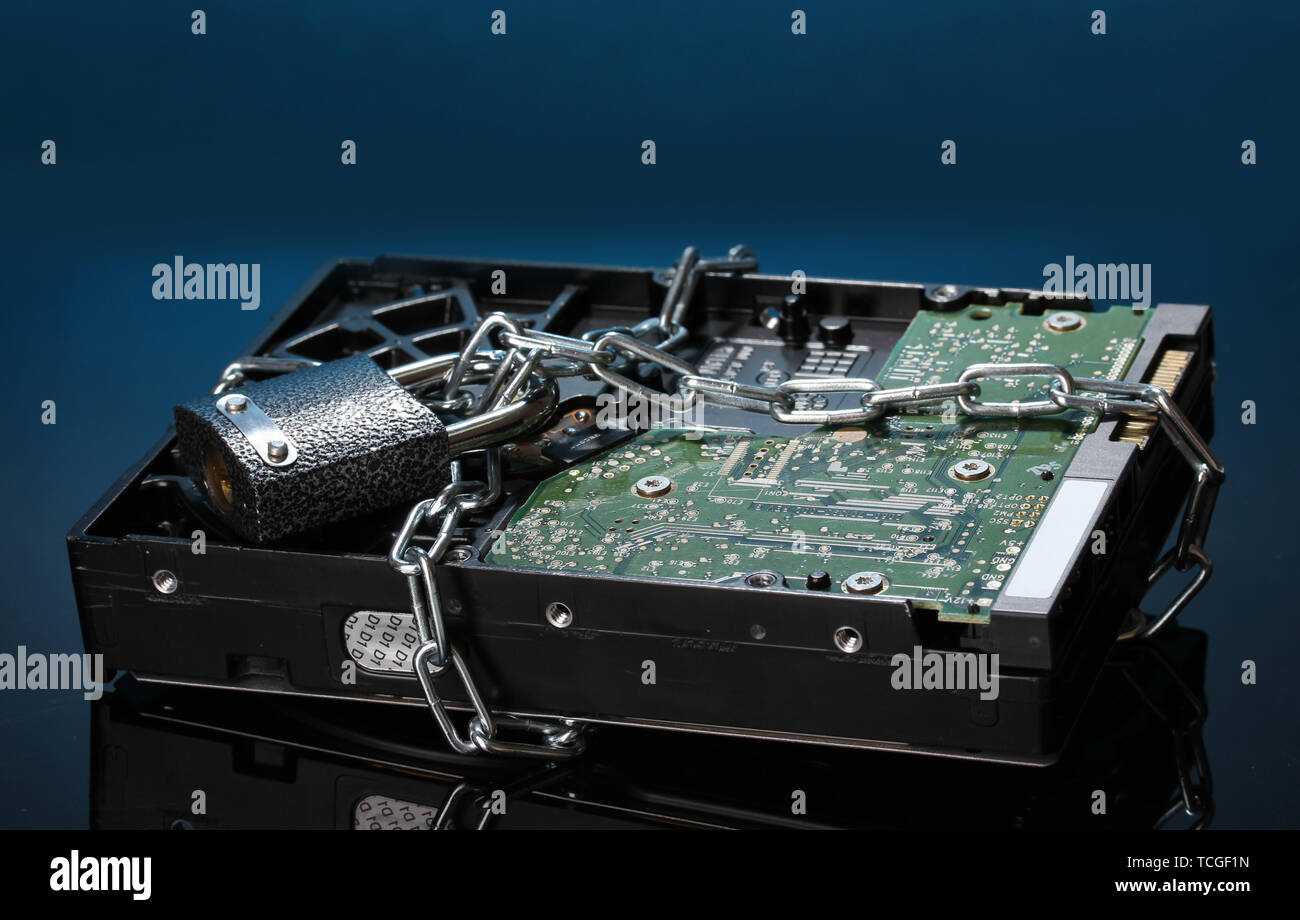 Hard disk drive on chain on dark blue background Stock Photo - Alamy