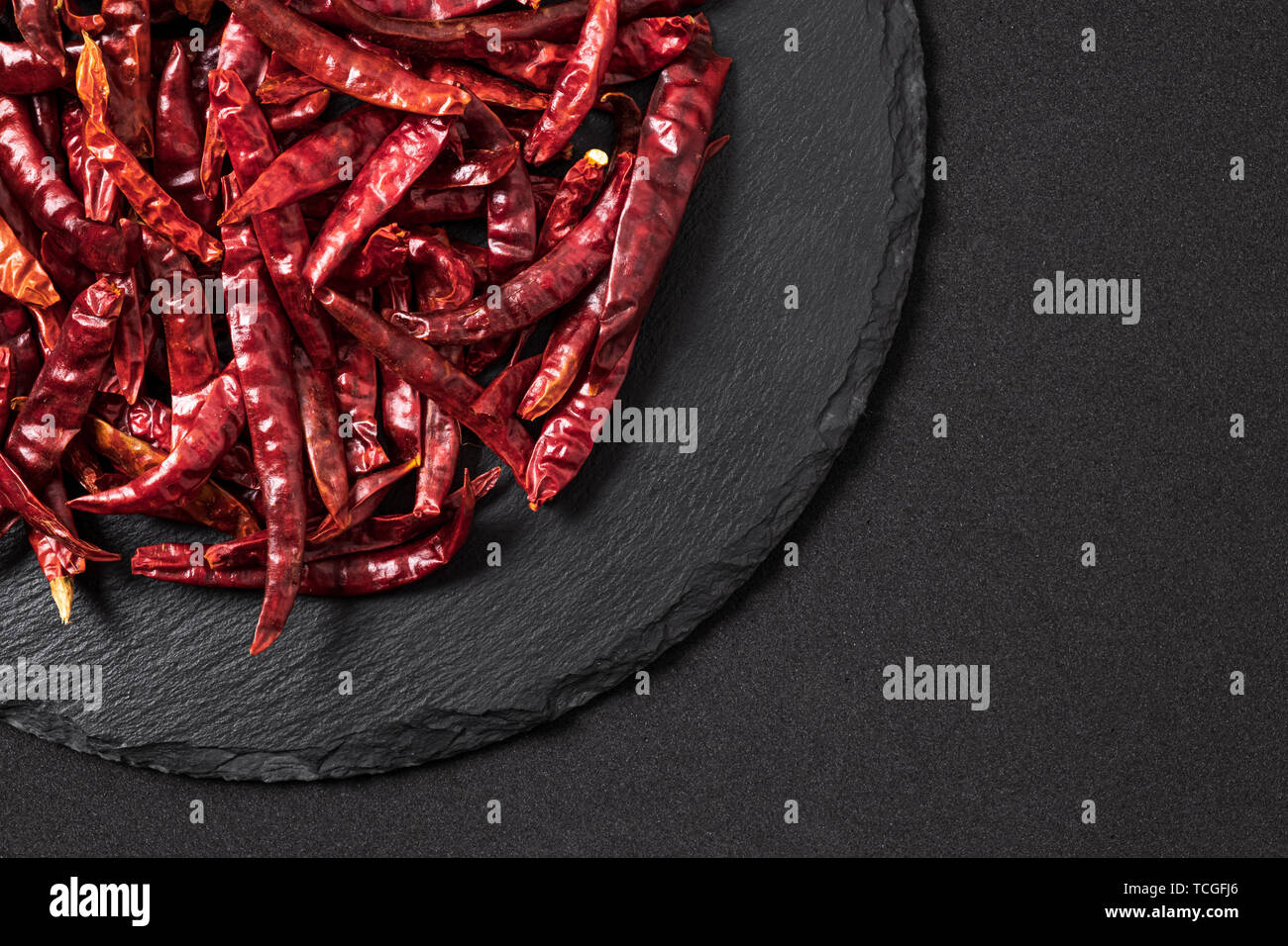 Red chili pepper dried. On a black slate . Free space for text . Stock Photo