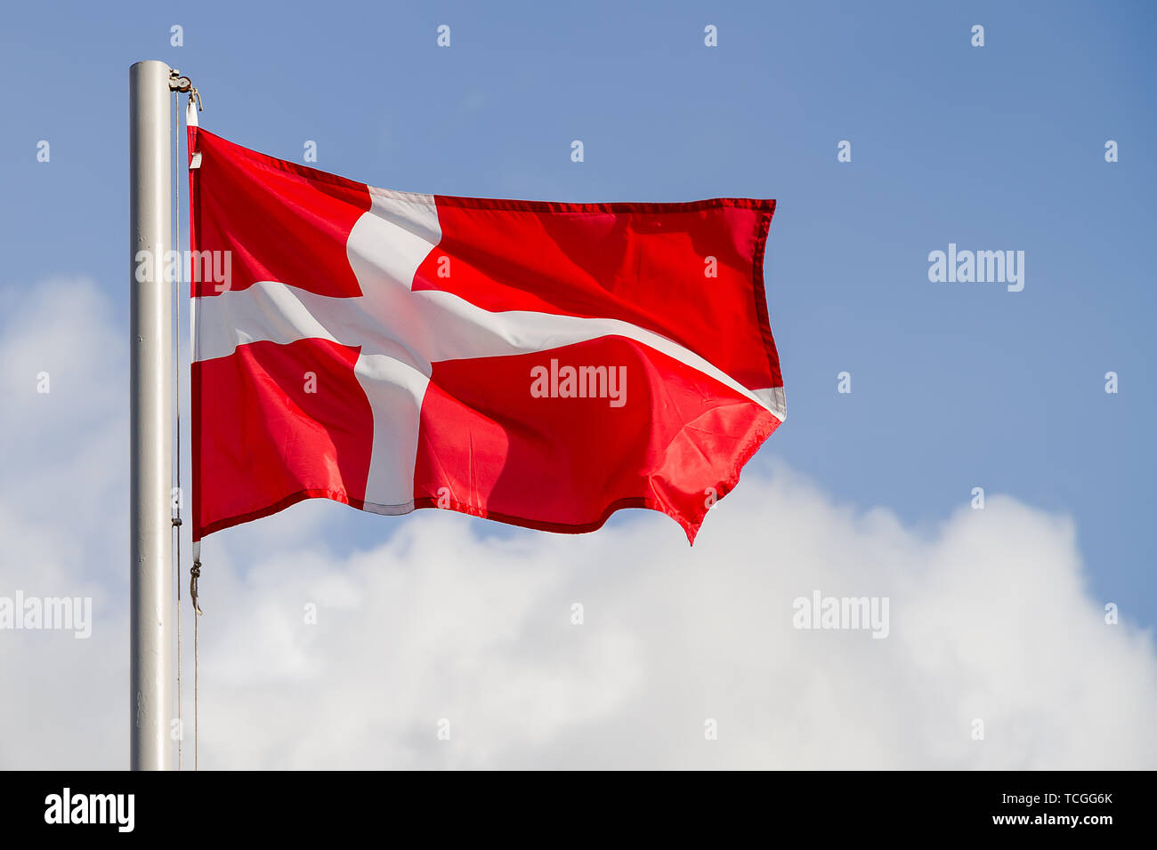 Denmark flag is waving in front of blue sky Stock Photo