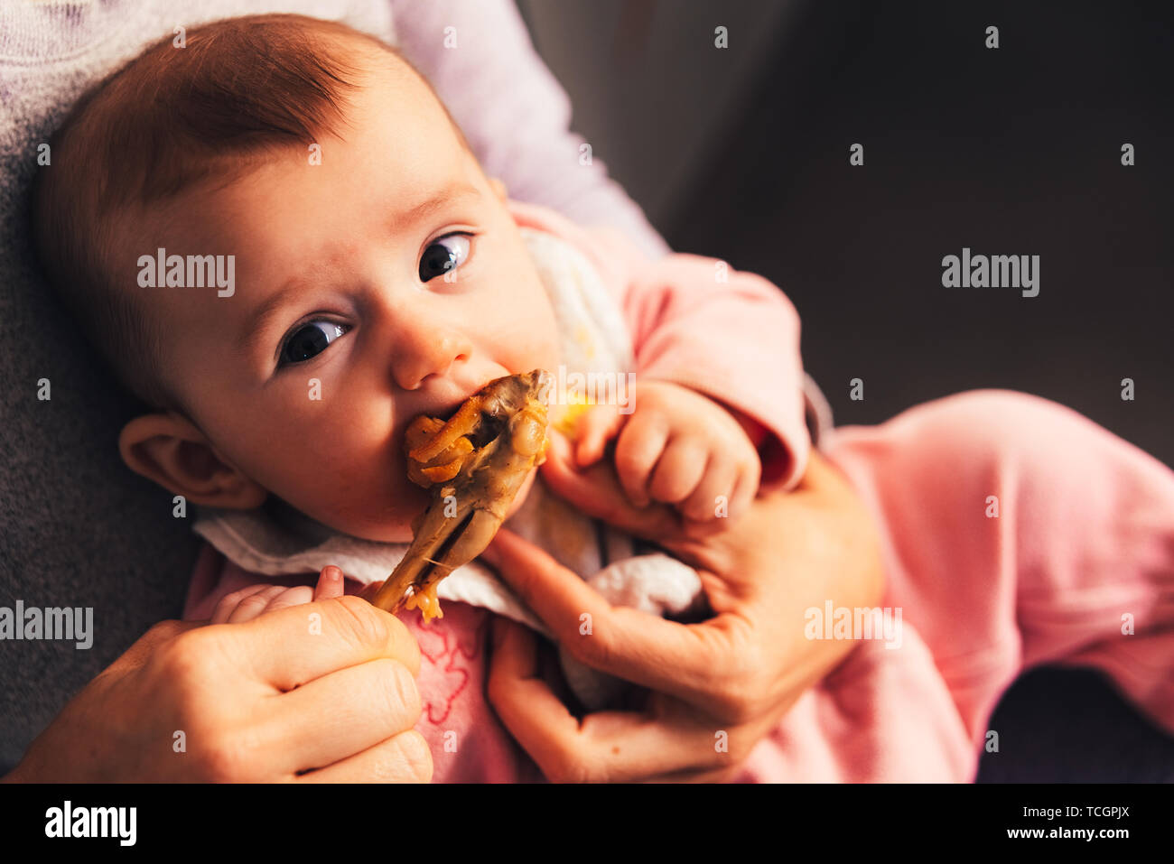 5 month old baby eating a chicken leg using the Baby led weaning BLW