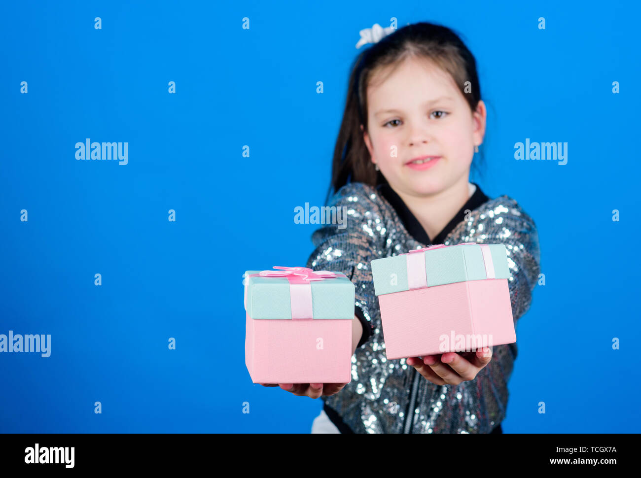 Shopping day. Cute child carry gift boxes. Surprise gift box. Birthday wish list. World of happiness. Special happens every day. Choose one. Girl with gift boxes blue background. Black friday. Stock Photo