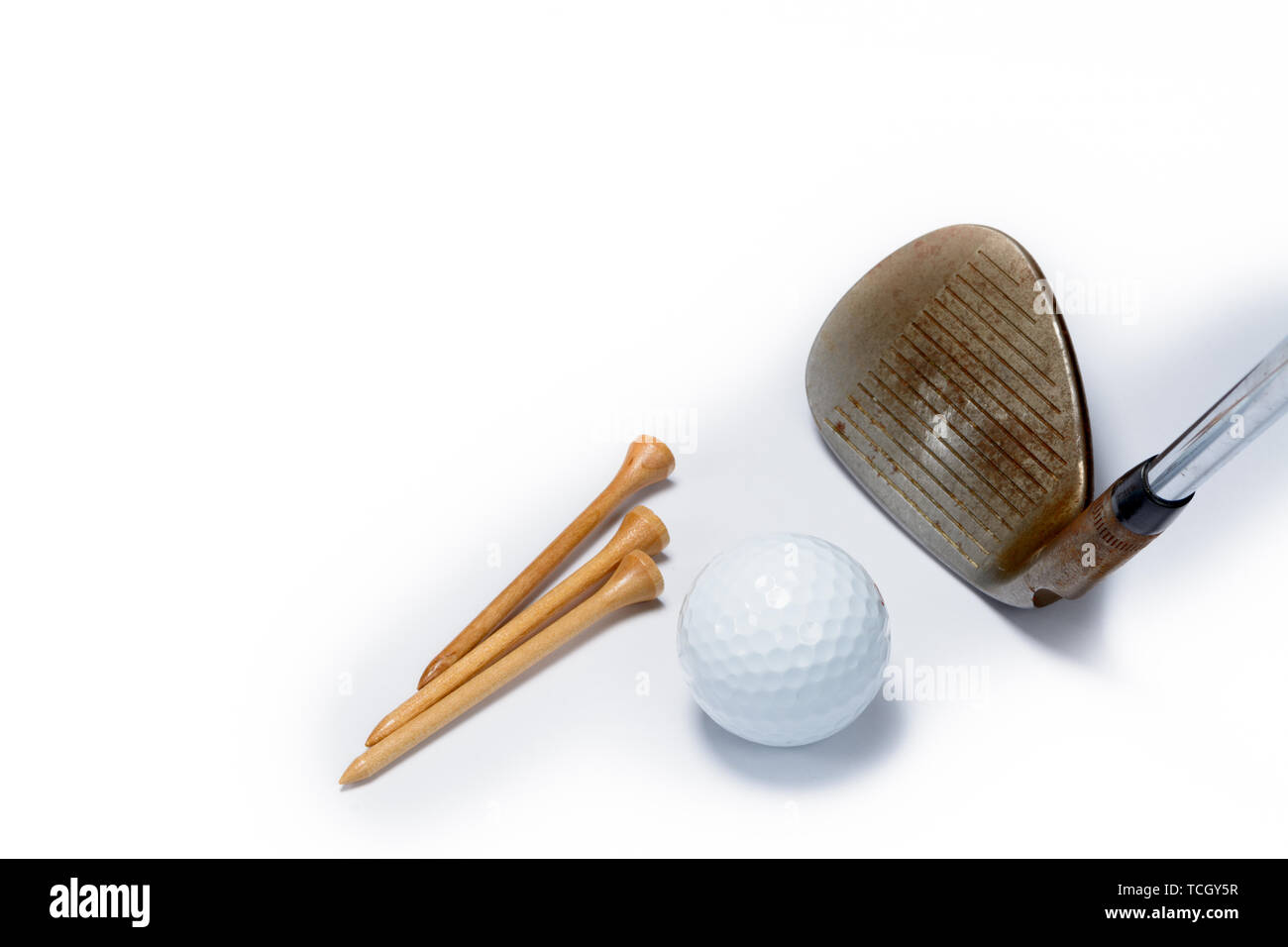 various golf equiptment on a white background. A golf ball, golf club sand wedge, and golf tees. Stock Photo