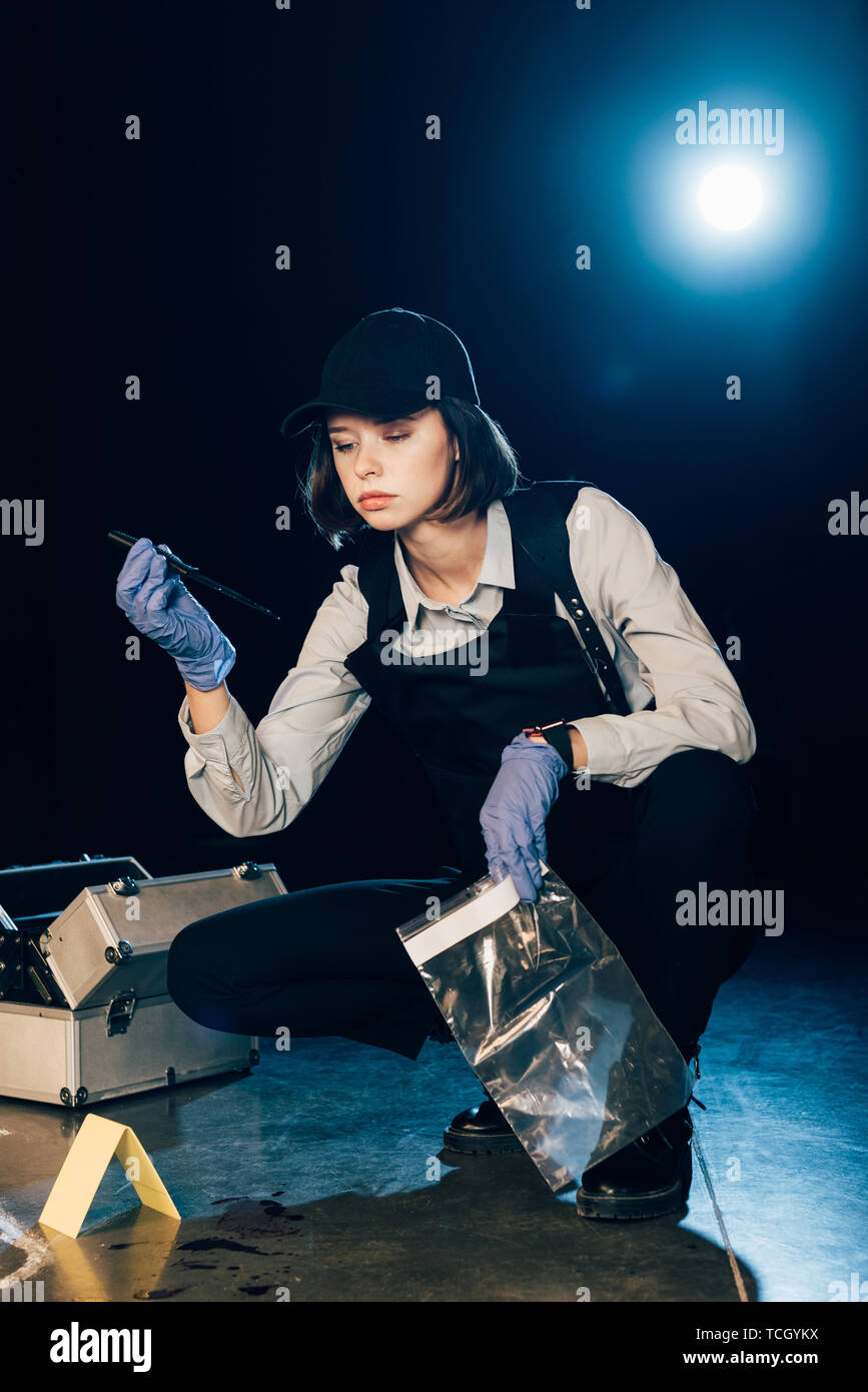 investigator holding knife and ziploc bag at crime scene Stock Photo