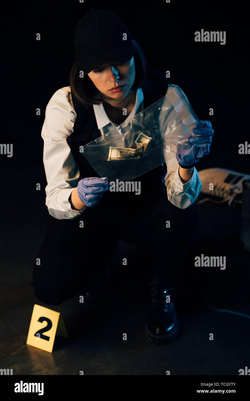 https://c8.alamy.com/comp/TCGYTY/investigator-in-rubber-gloves-holding-ziploc-bag-with-dollar-banknote-at-crime-scene-TCGYTY.jpg