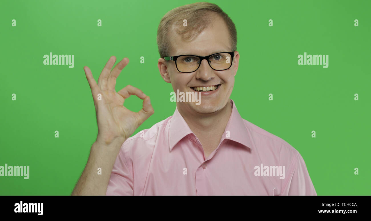 Caucasian man in glasses showing OK gesture. Guy in pink shirt. Green  screen. Chroma key Stock Photo - Alamy