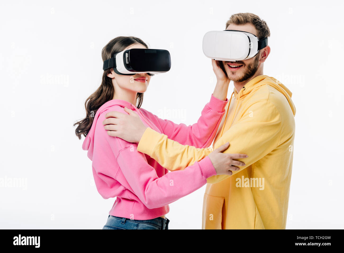 young man and woman embracing while using virtual reality headsets ...