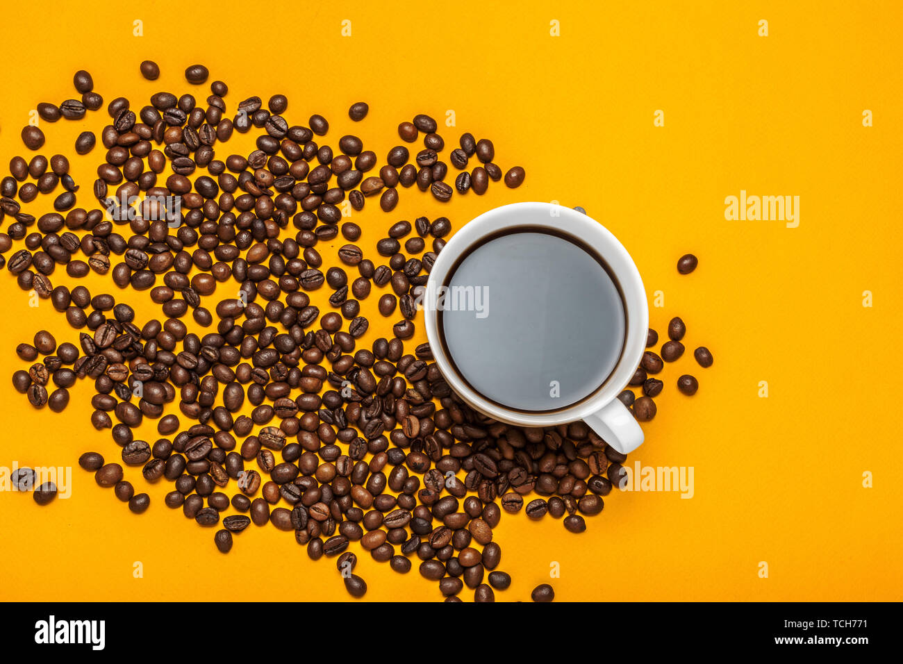 Spilled coffee beans on a bright yellow background Stock Photo Alamy