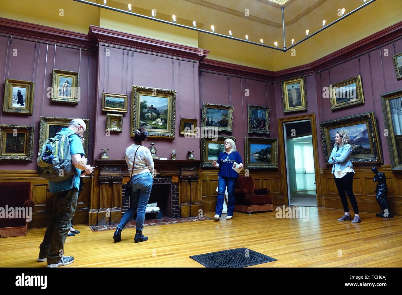 Visitors in the exhibit hall are treated to a guide's commentary. Arnot art museum, Elmira,  New York Stock Photo