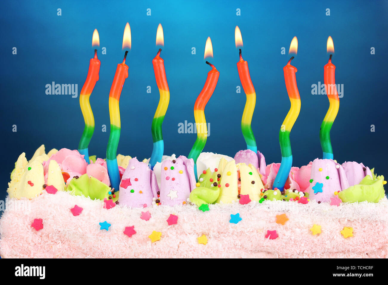 Birthday cake with candles on blue background Stock Photo - Alamy