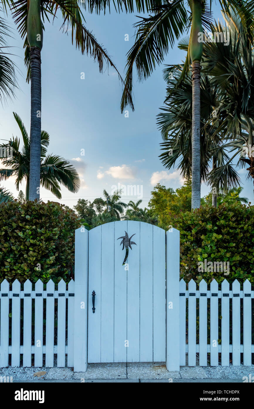 White picket fence and wood gate with palm tree cutout, Naples, Florida, USA Stock Photo