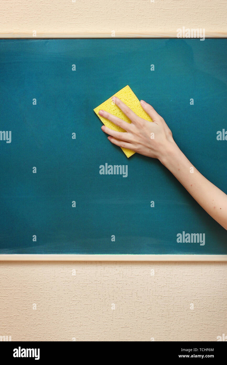 hand with a yellow sponge cleaning the chalkboard Stock Photo Alamy