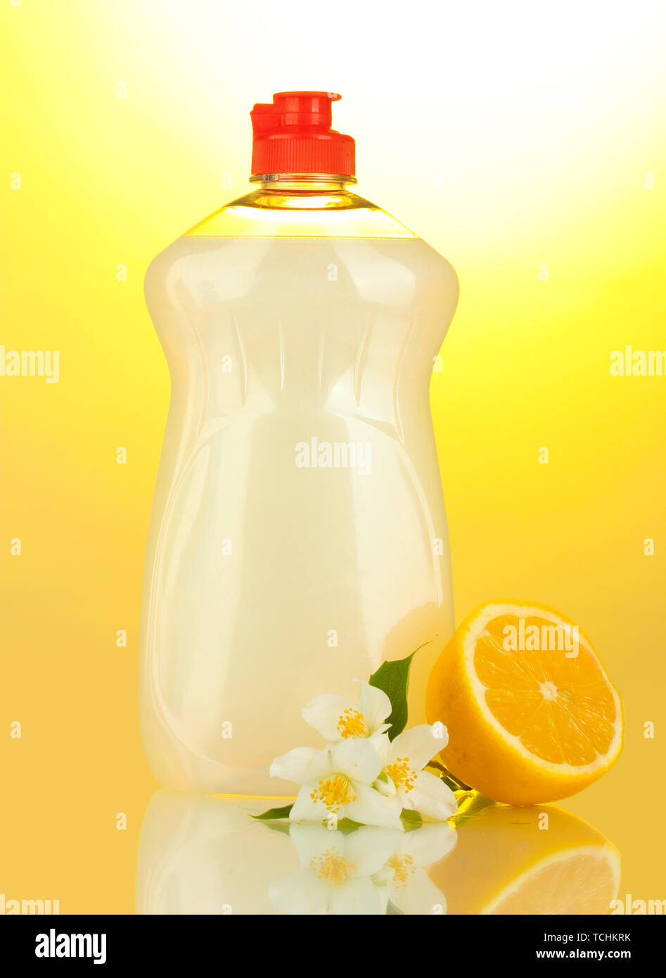 Dishwashing liquid, lemon and flowers on yellow background Stock Photo ...