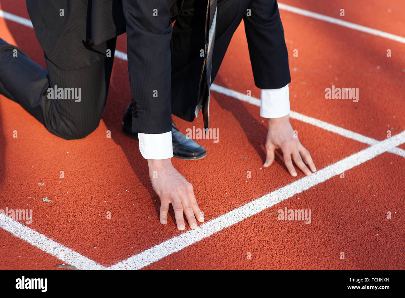 Business man waiting for start signal to run on the competition running track Stock Photo