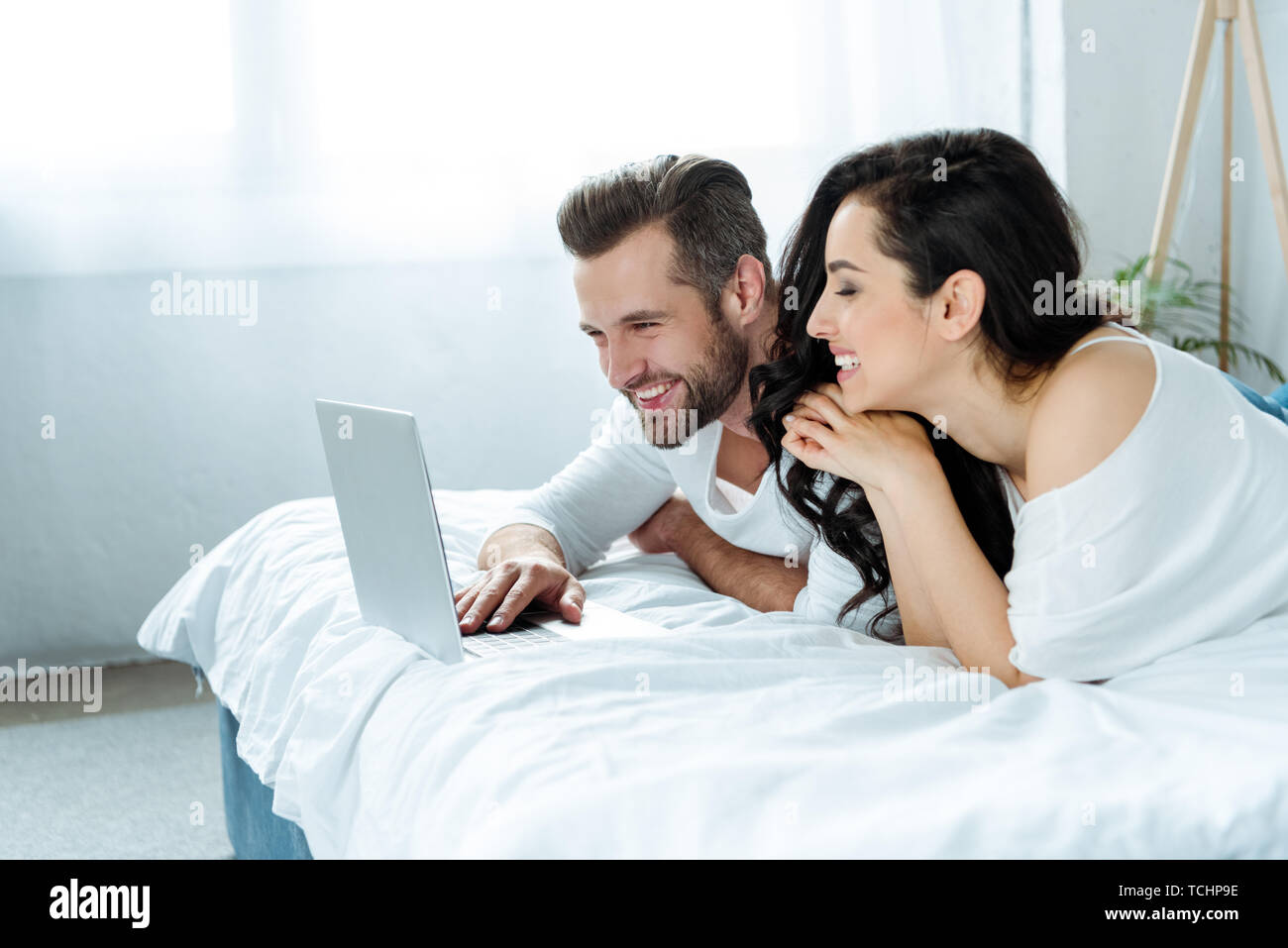 happy smiling couple using laptop in bed together Stock Photo - Alamy