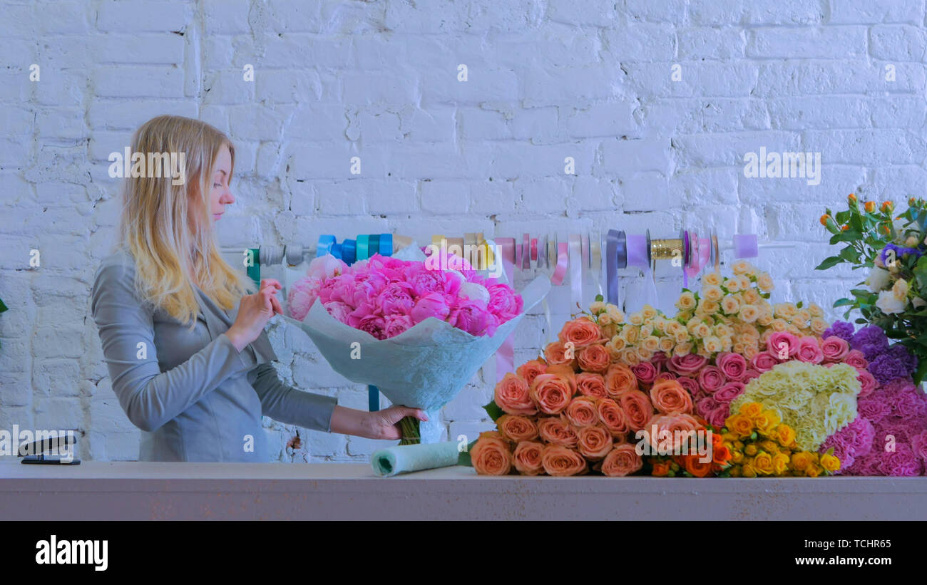 Florist holding pink peonies bouquet at flower shop Stock Photo - Alamy