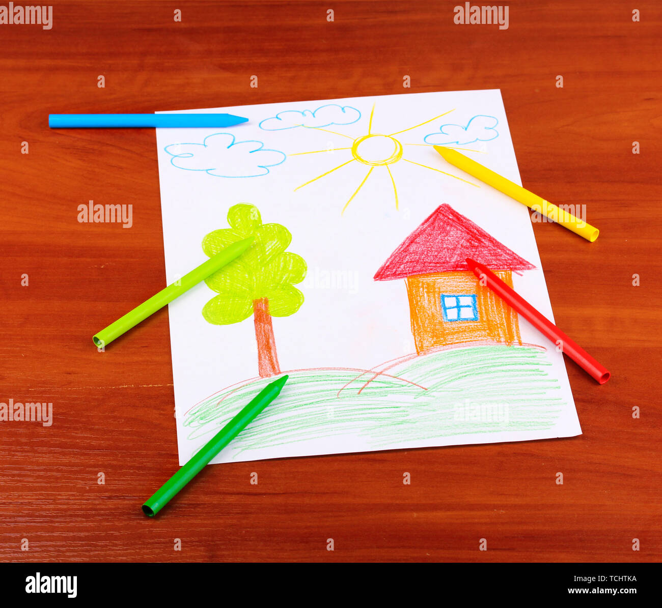 Kids drawing of family and colored pencils on wooden table Stock Photo -  Alamy