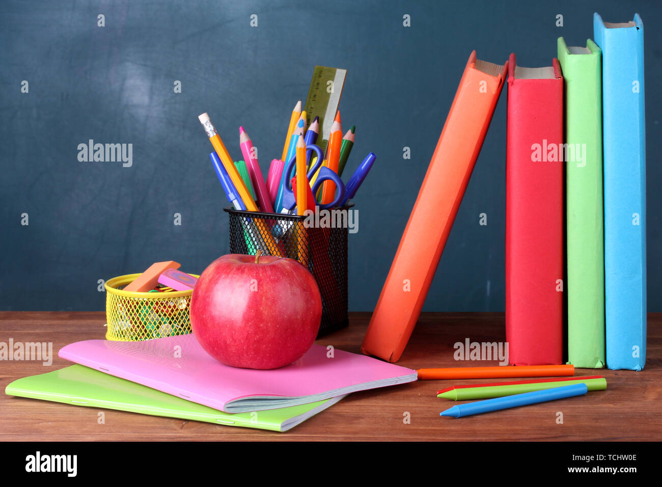 Composition Of Books Stationery And An Apple On The Teacher S Desk In The Background Of The Blackboard Stock Photo Alamy