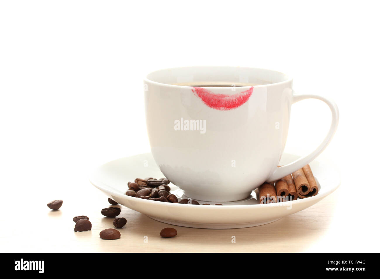 cup of coffee with lipstick mark beans and cinnamon sticks isolated on