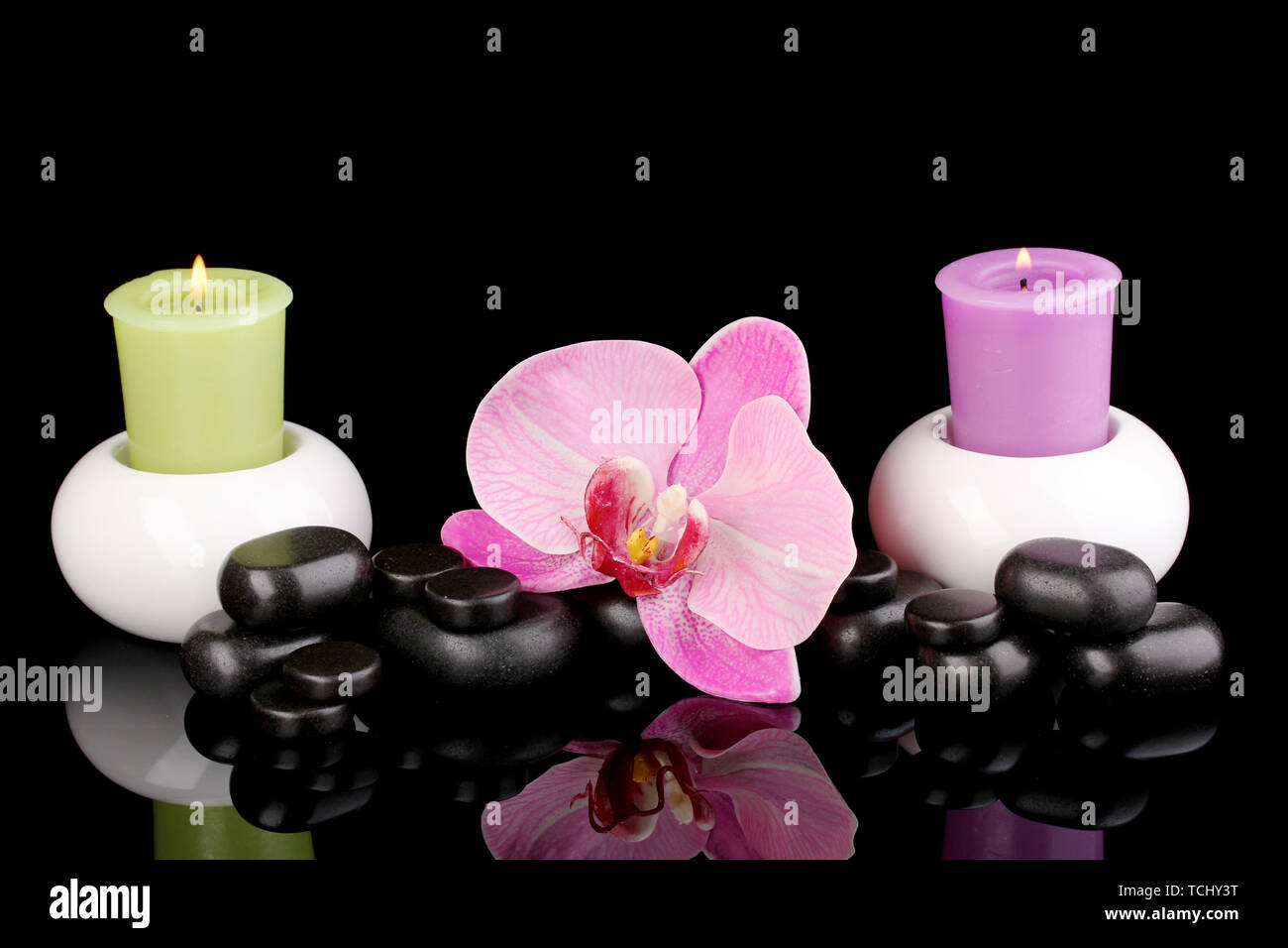 Spa stones with orchid flower and candles isolated on black Stock Photo ...