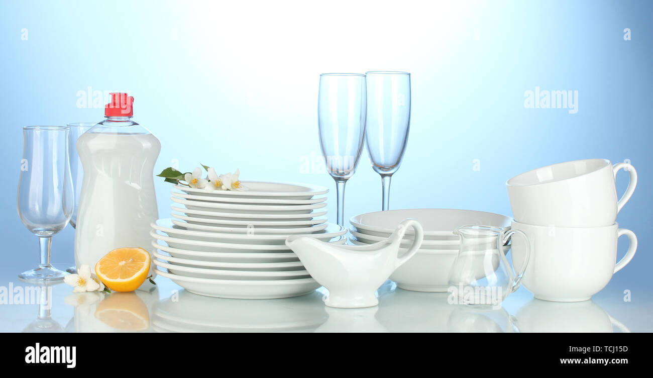 empty clean plates, glasses and cups with dishwashing liquid and lemon