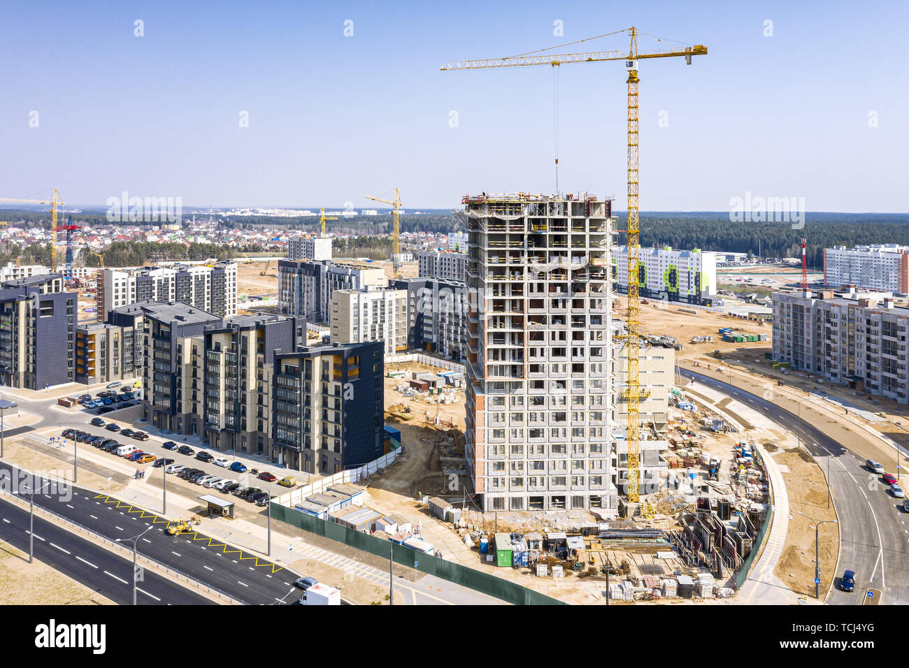 aerial view of city construction site. high yellow tower crane on blue ...