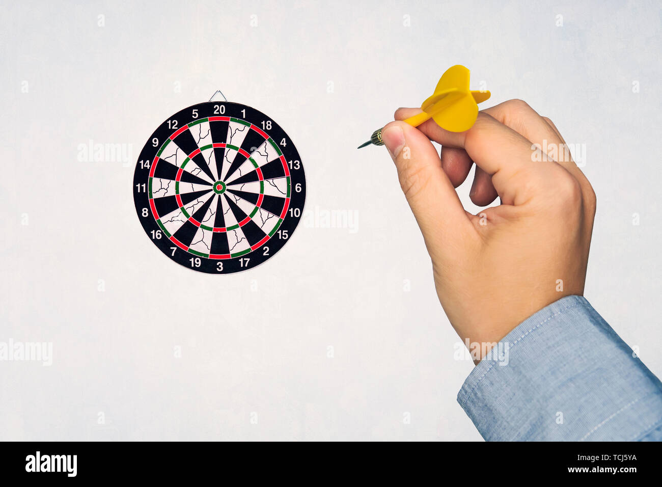 Human hand is throwing the darts target to the darts board. a man's hand  throws a dart at the target Stock Photo - Alamy