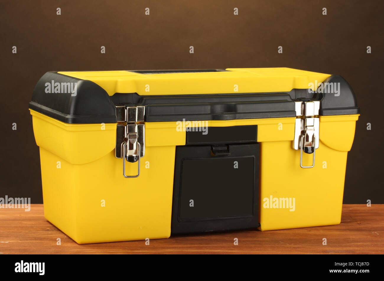yellow tool box on brown background close-up Stock Photo - Alamy