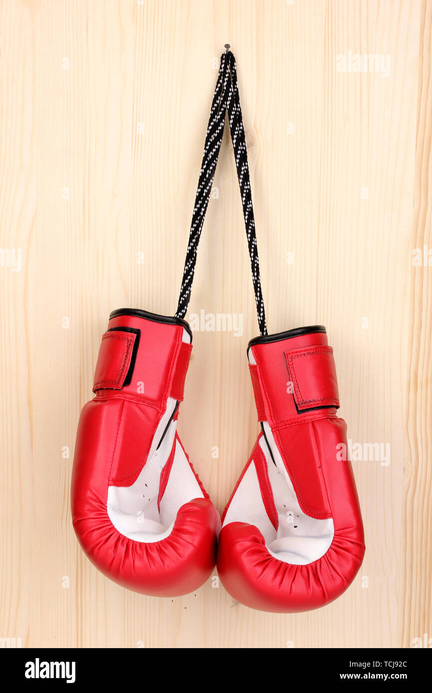 Red boxing gloves hanging on wooden background Stock Photo