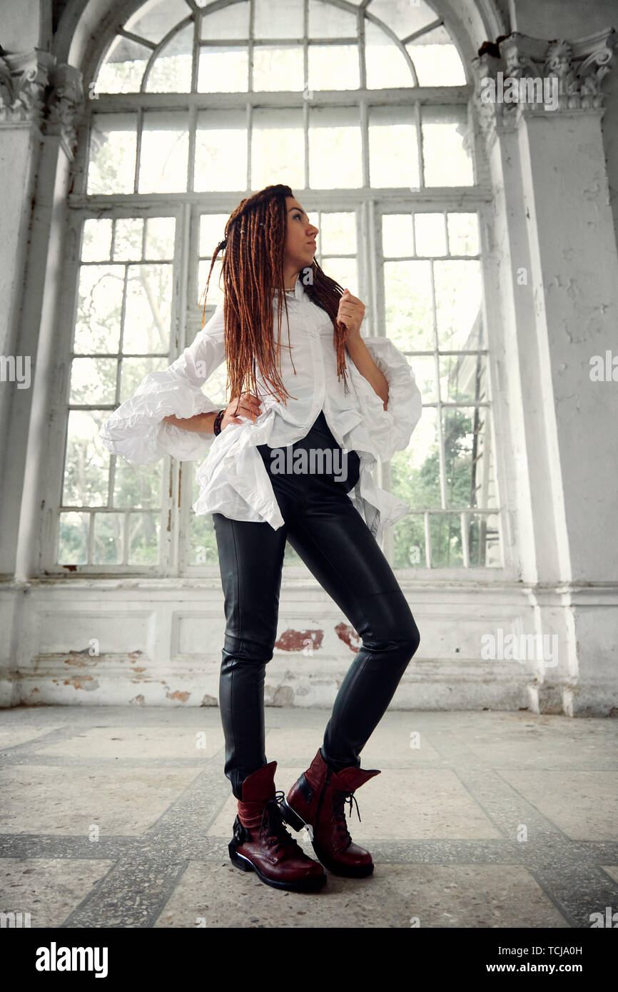 Beautiful girl in black leather pants. on a white Stock Photo - Alamy