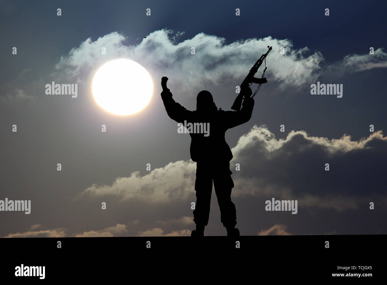 Silhouette of military soldier or officer with weapons at sunset. shot, holding gun, colorful sky, Concept of a terrorist. Silhouette terrorists with  Stock Photo