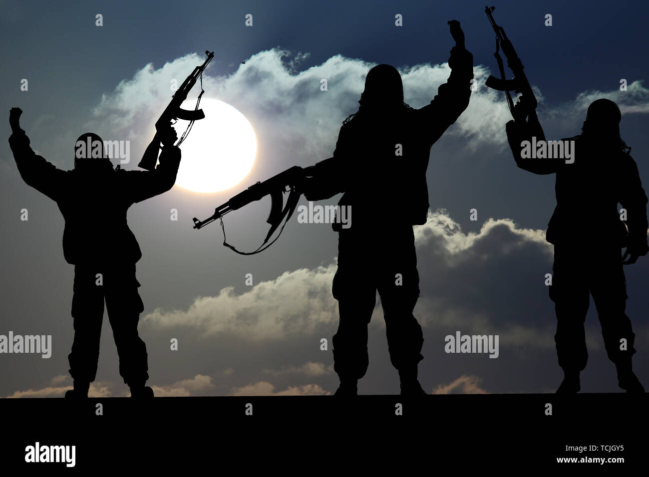 Silhouette of military soldier or officer with weapons at sunset. shot, holding gun, colorful sky, Concept of a terrorist. Silhouette terrorists with  Stock Photo
