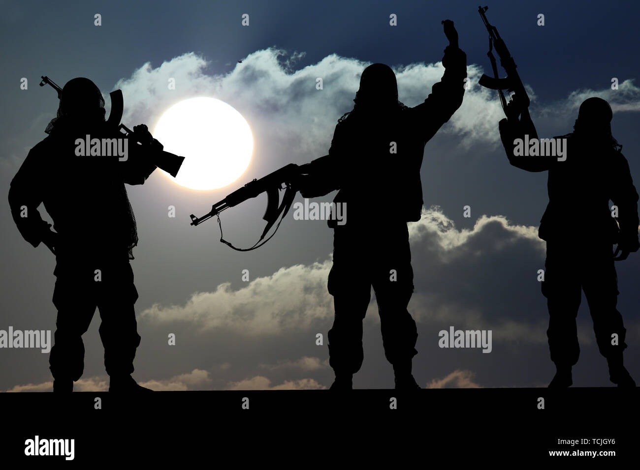 Silhouette of military soldier or officer with weapons at sunset. shot, holding gun, colorful sky, Concept of a terrorist. Silhouette terrorists with  Stock Photo